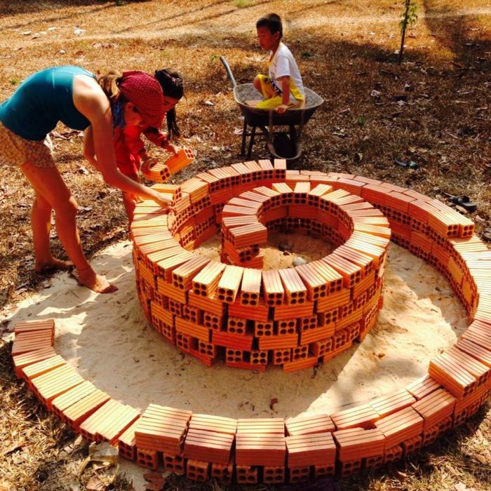 Pierre en spirale d'herbes petites pierres pleines de fleurs splendides travaux de construction en spirale d'herbes